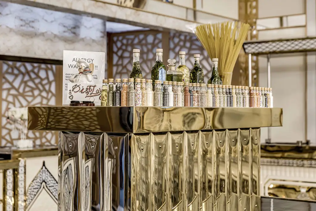 Mirrored gold bar station with glassware and decorative dried grasses