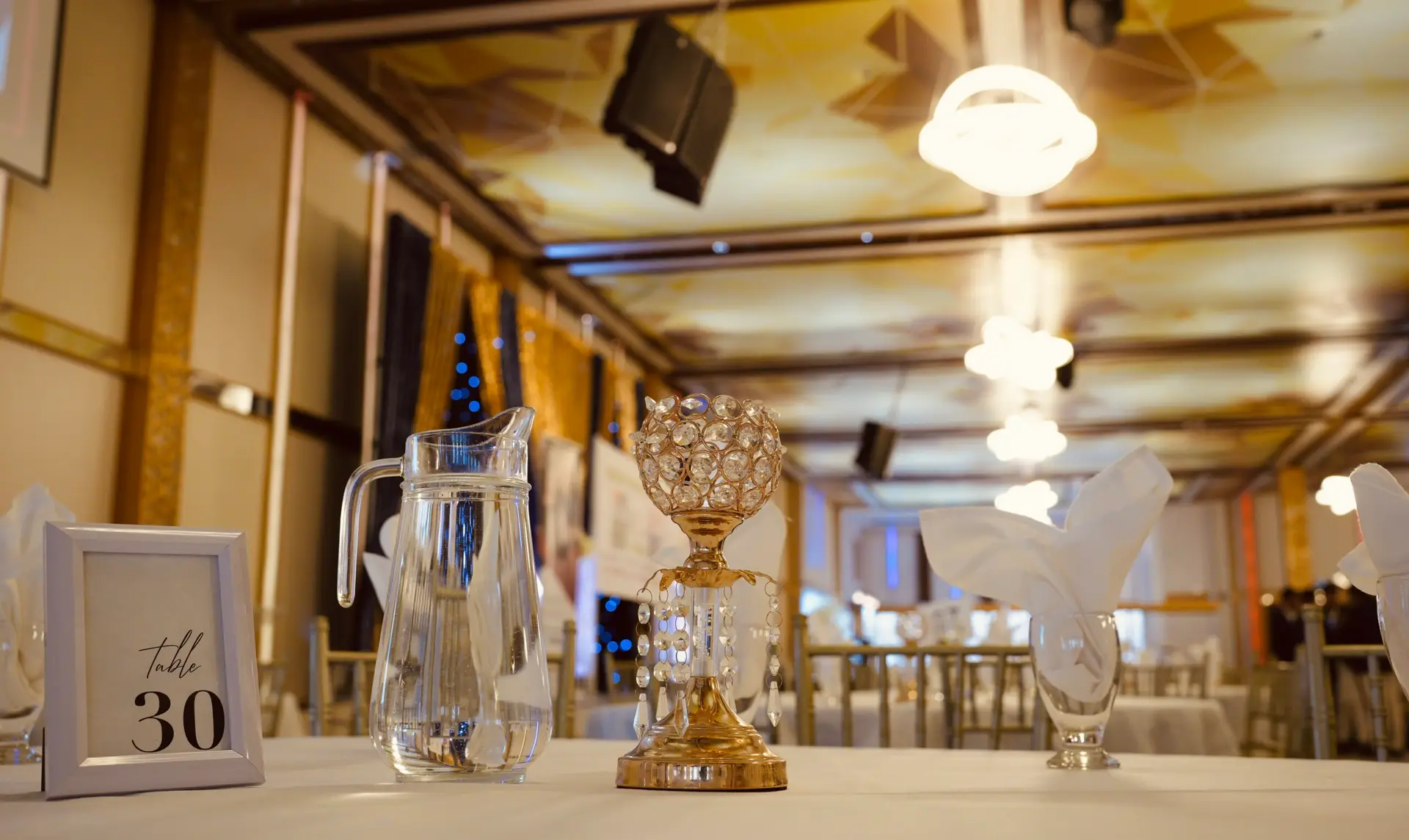 Table set with a water pitcher, table number card and crystal centrepiece